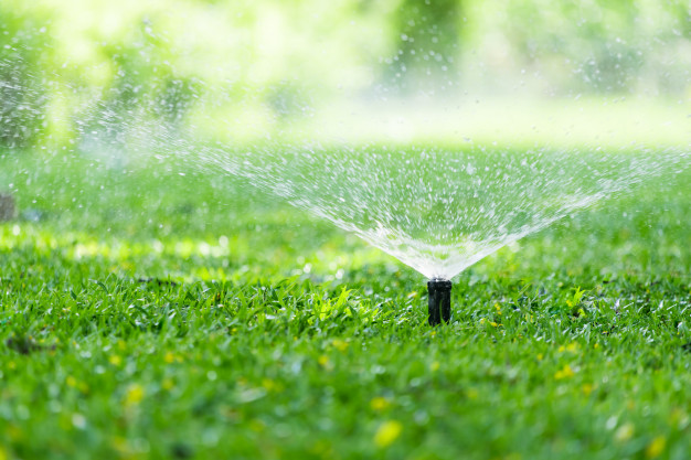aspersor-automatico-cesped-jardin-accion-regando-pasto_103077-3